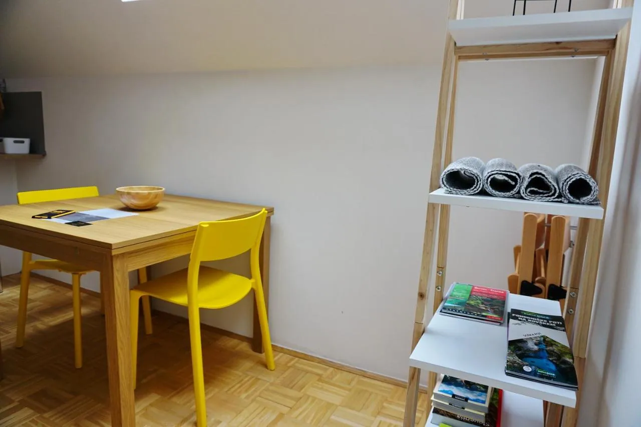 Lesena jedilna miza z rumenimi stoli v apartmaju Sončna stran